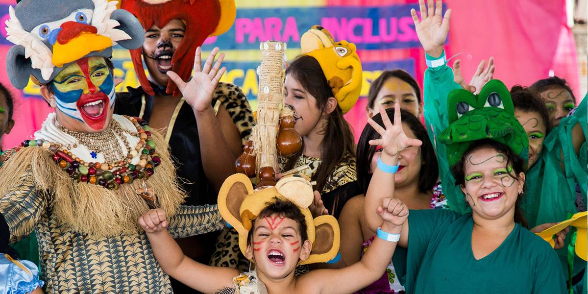 Crianças de diferentes idades fantasiadas e maquiadas de animais posam animadas